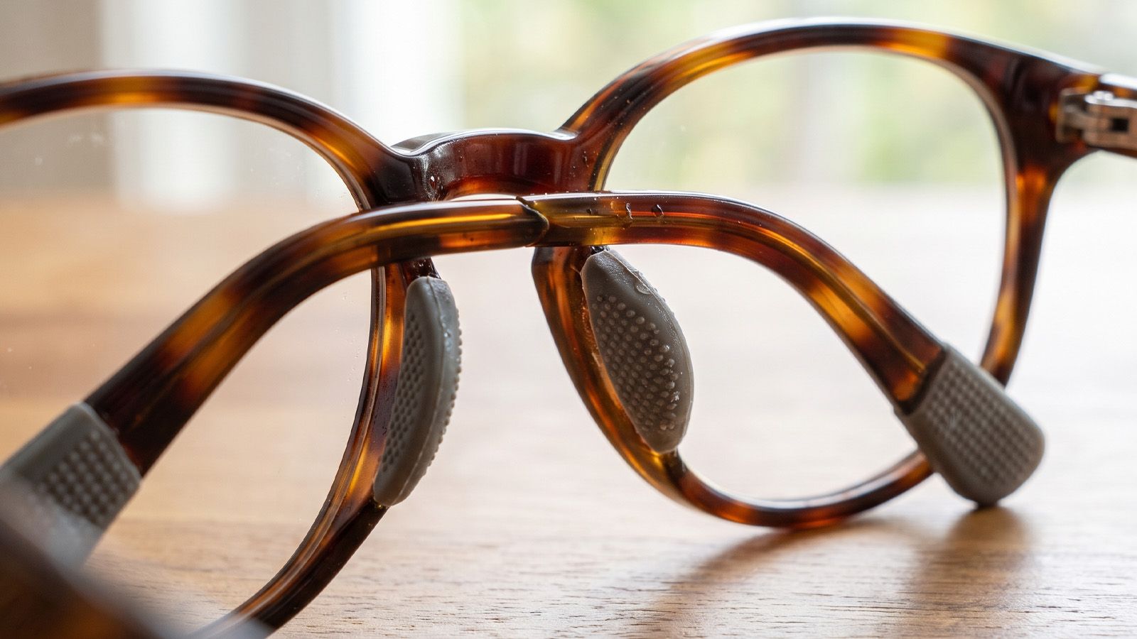 Hand adjusting metal nose pads on eyeglasses for a better fit