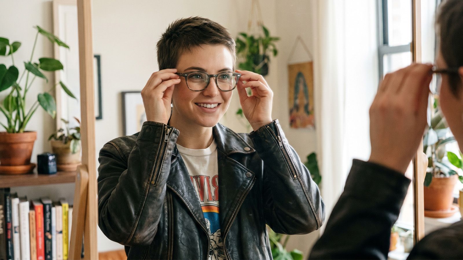 a person adjusting new glasses in a mirror with an expression of adapting