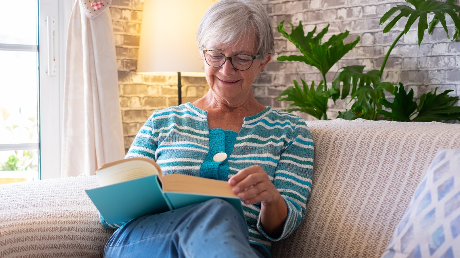 Senior woman smiling and reading comfortably with corrective plus lenses for hyperopia.