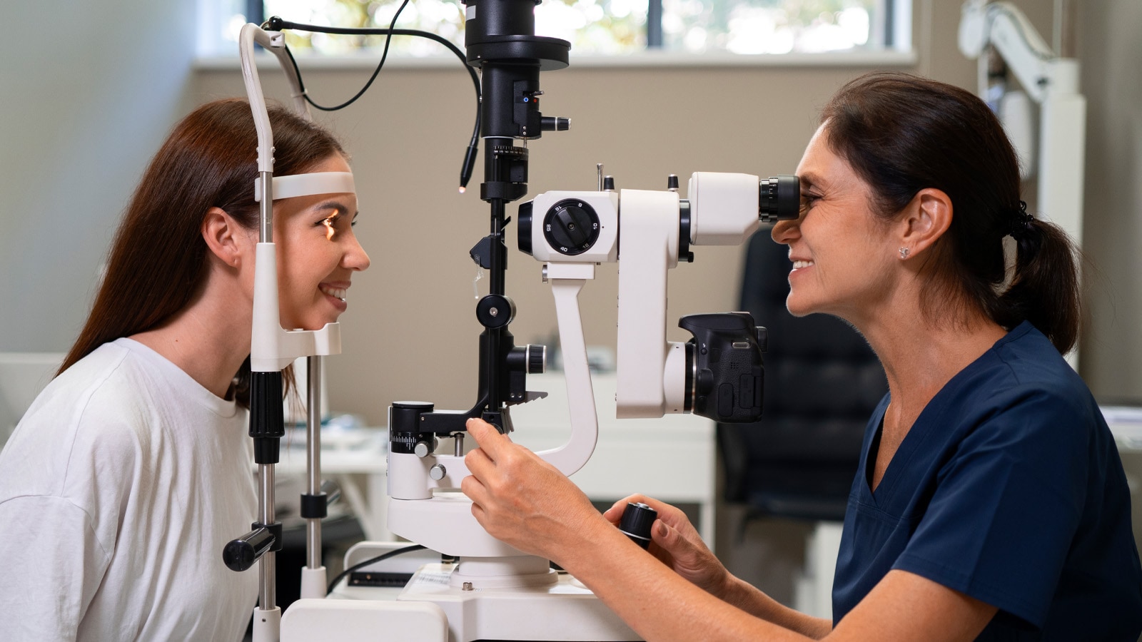 Optometrist performing a comprehensive dilated eye examination on a patient, essential for early detection of diabetic retinopathy.