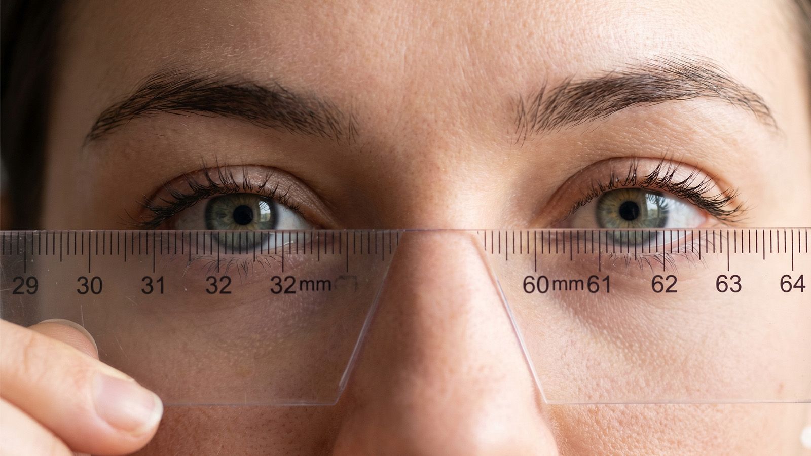 Eyes close-up with ruler on nose bridge to measure pupillary distance