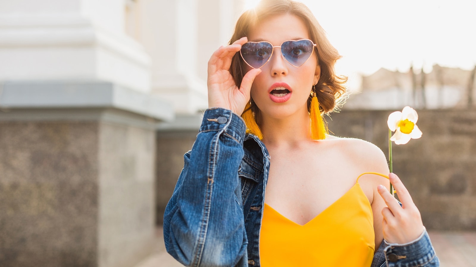 A fashionable woman wearing stylish heart-shaped sunglasses, representing the variety of modern frame styles available for transition lenses.