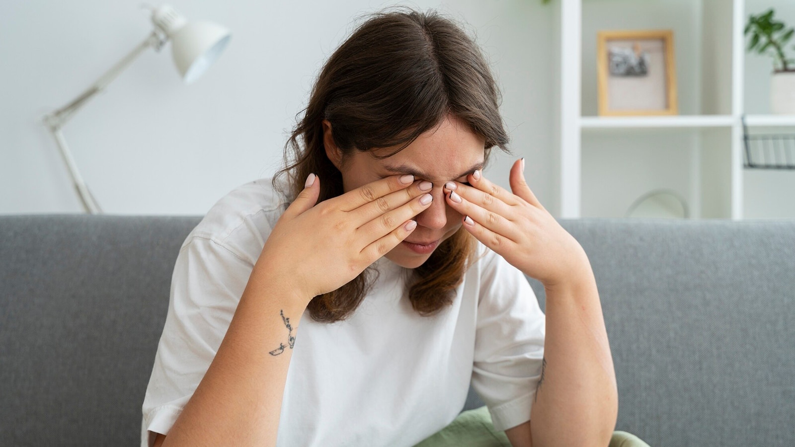 Woman rubbing her eyes with a concerned expression, illustrating discomfort from eye floaters or flashes.